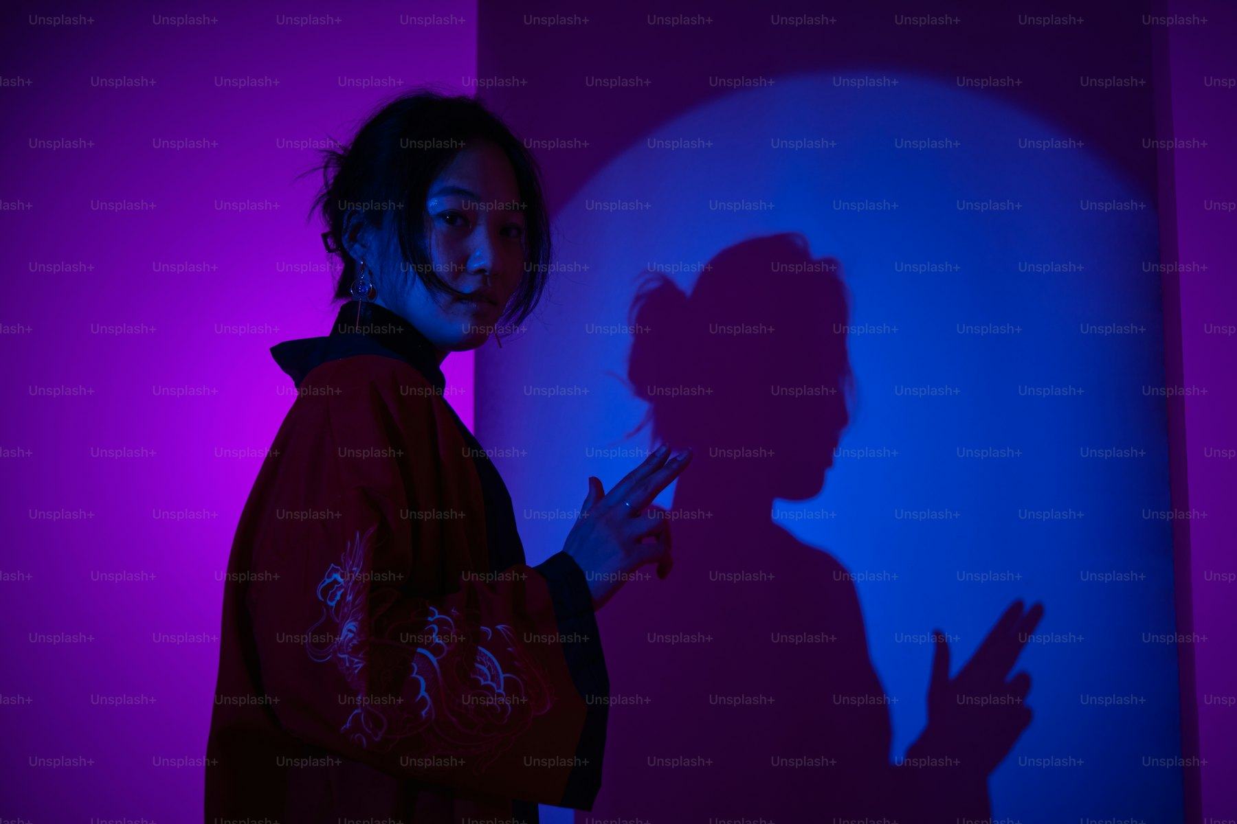 Creator posing against a wall of coloured light