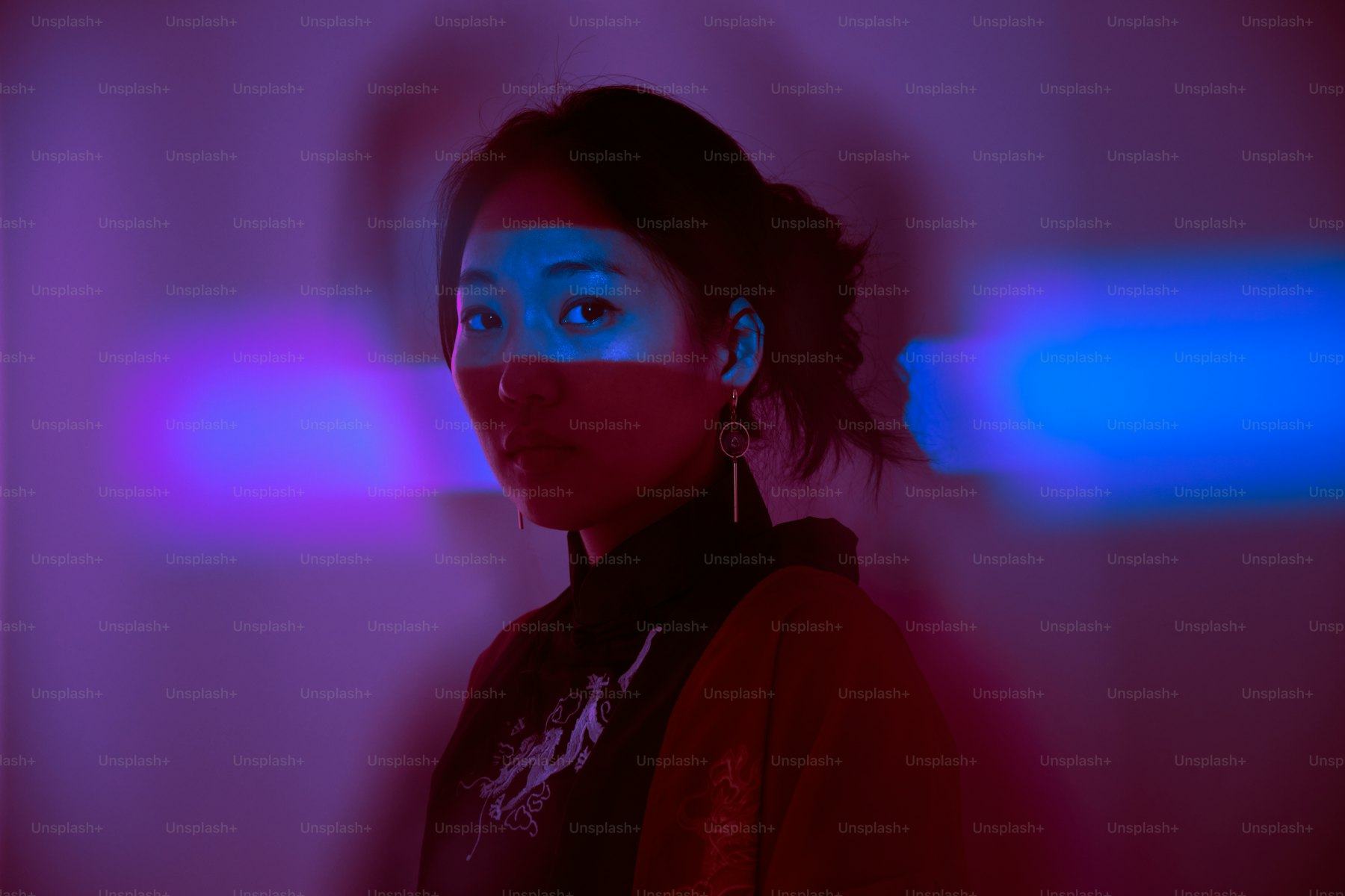 Portrait lit by neon in a dark room