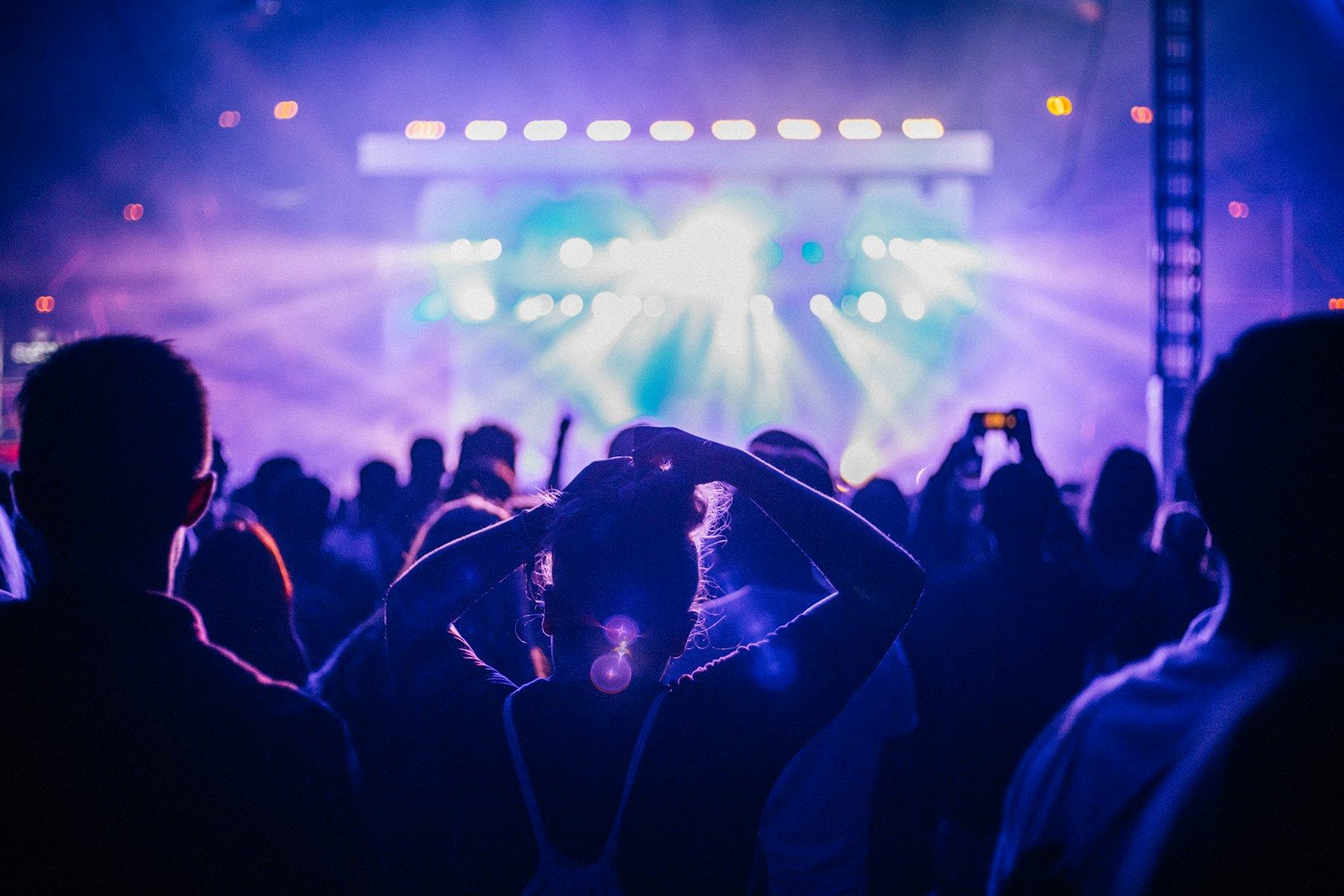 Crowd lit by purple stage lights at a live show