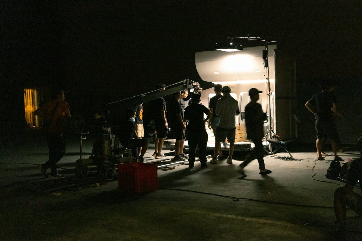 Film crew setting up cameras and lighting on a night shoot